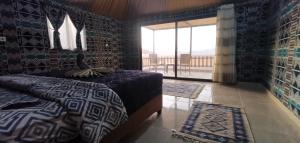 DisahRemal Wadi Rum Camp & Tour的一间卧室设有一张床和一个美景窗户。