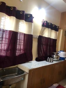 巴德拉恰拉姆Kodali Homestays的厨房配有带水槽的台面上的窗帘