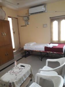 巴德拉恰拉姆Kodali Homestays的一间设有两张床和一张桌子及椅子的房间