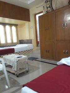 巴德拉恰拉姆Kodali Homestays的一间设有两张床的房间和一个橱柜