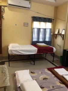 巴德拉恰拉姆Kodali Homestays的客房设有两张床和窗户。