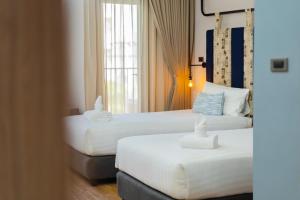 合艾W3 Hotel的酒店客房设有两张床和窗户。