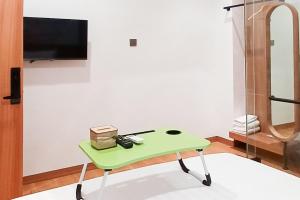KubukUrbanview Hotel R House Batuaji的配有电视的客房内的绿桌