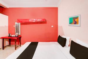 比莱OYO Hotel Abhilasha的红色的房间,设有一张床和红色的墙壁