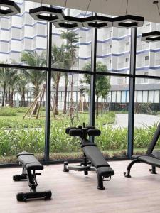 金兰The Arena Apartment Cam Ranh - Free Pool的一个带椅子和大窗户的健身房