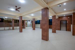 哥印拜陀MUGUNDAN 'S SMART STAY的大房间设有圆柱和吊扇