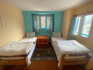 Nāmche BāzārHimalayan Lodge的客房设有两张单人床和一扇窗户。