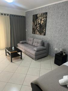 马科普隆AVR Airport Deluxe Suites 4的客厅配有沙发和桌子