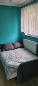 肯琴Spokojne i miłe miejsce na Mazurach的卧室内的一张床铺,卧室内有蓝色的墙壁