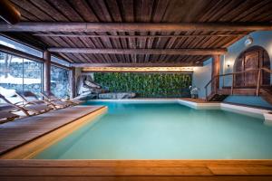 达沃斯Hotel Flüela Davos - The Unbound Collection by Hyatt的房屋内带椅子的游泳池