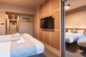 大阪住一道顿堀2号店的酒店客房设有两张床和一台平面电视。