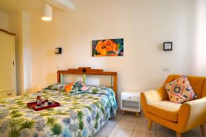 阿尔盖罗花卉别墅旅馆的一间卧室配有一张床和一把椅子