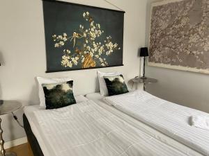 卢马Brohuspark的一间卧室设有两张床,墙上挂着一幅画
