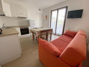 托尔博莱Casa Martinelli的一间带橙色沙发的客厅和一间厨房