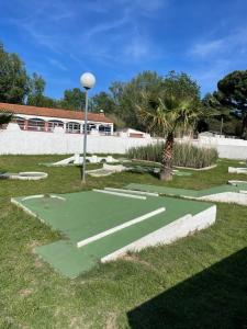 滨海阿热莱斯Mobil home charmant的棕榈树庭院中的高尔夫球场