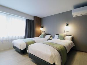 山之内町伊其博卡库酒店的酒店客房设有两张床和窗户。