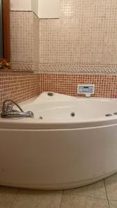 科森扎Luxury Room Cosenza的瓷砖浴室设有白色浴缸。