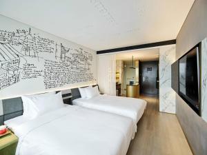 上海张江CitiGO欢阁酒店X的一张带画图的墙壁的房间里,有两张床