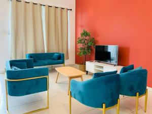 边佳兰30pax Desaru Pengerang Home的客厅配有蓝色椅子和电视