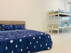 边佳兰30pax Desaru Pengerang Home的一间卧室配有一张蓝色的床和波卡圆点