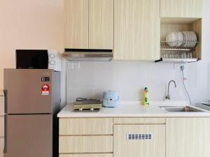 边佳兰30pax Desaru Pengerang Home的厨房配有冰箱和水槽