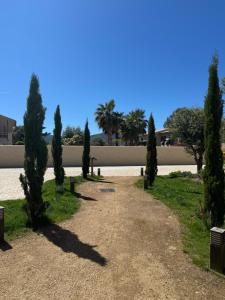 圣弗洛朗Résidence CATALINA的公园里一排树木,有一座建筑