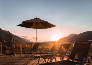 特洛普拉赫萨玛霍夫酒店的日落时分带椅子和遮阳伞的甲板