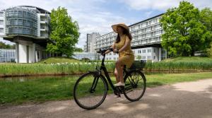 波茨坦Kongresshotel Potsdam am Templiner See的骑着自行车的女人