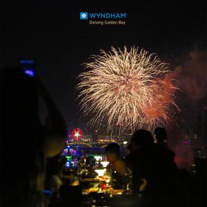 岘港Wyndham Danang Golden Bay的夜间的烟花展示,背景是城市