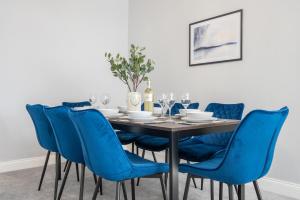 纽波特Brynglas House by Tŷ SA的一间带一张桌子和蓝色椅子的用餐室
