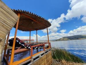 普诺Uros Titicaca UMA lodge的船上配有椅子和雨伞