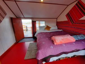 普诺Uros Titicaca UMA lodge的一间带床的卧室,位于带窗户的房间内