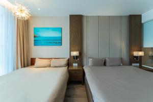 芽庄Panorama Superview Nha Trang Apartment的一间卧室配有两张床和吊灯。