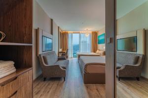 芽庄Panorama Superview Nha Trang Apartment的酒店客房,配有一张床和两把椅子