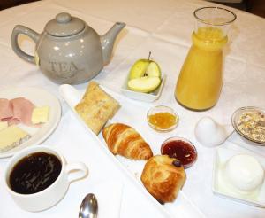 昂热博帕斯图尔旅馆的一张桌子,上面放着早餐食品和茶壶
