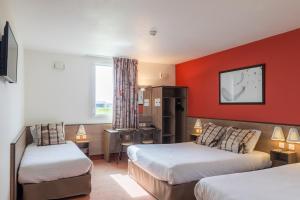 圣安德烈莱韦尔热特鲁瓦艾斯酒店的酒店客房设有两张床和红色的墙壁。