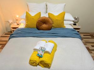 劳托卡“Marley’s Home“的一张带黄色和白色枕头的床和毛巾