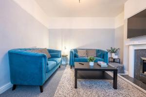 纽波特Dos Road by Tŷ SA的客厅配有2张蓝色沙发和1张咖啡桌