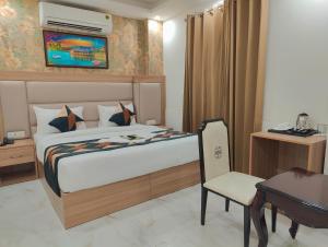 新德里Hotel Decent Aerocity - Mahipalpur, Delhi Airport的一间卧室配有一张床、一张桌子和一把椅子