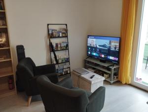 MontgaillardLe petit nid的客厅配有平面电视和椅子