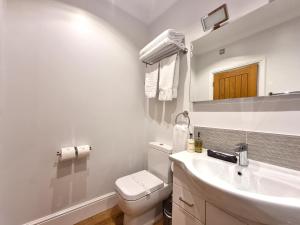 兰迪德诺Min y Don Llandudno的白色的浴室设有卫生间和水槽。