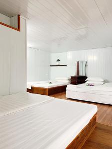三岛县Chân Mây Tam Đảo的配有白色墙壁和木地板的客房内的两张床