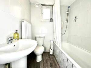 伦敦Serviced 4 bed 2 bath Manor Park House的白色的浴室设有水槽和卫生间。
