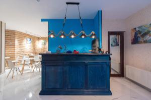 第比利斯Kraveli Hotel的一个带蓝色墙壁的厨房和一个饭厅