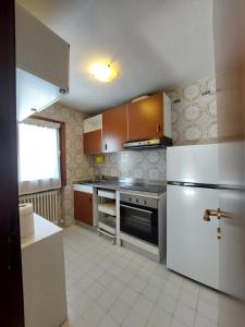 摩德纳迪-坎皮格里奥Quadrilocale Alberti - Residence dei Fiori的厨房配有白色冰箱和炉灶。