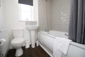 纽波特Gwent View by Tŷ SA的白色的浴室设有卫生间、浴缸和水槽。