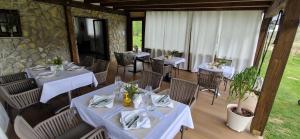 耶泽尔采Plitvice Inn的餐厅配有桌椅和白色桌布