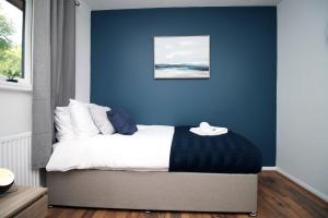 LlanwernLangstone Close by Tŷ SA的一间卧室设有蓝色的墙壁和床