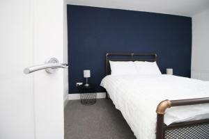 Quakers YardStation Terrace by Tŷ SA - 3 Bed in Mountain Ash的一间卧室配有一张蓝色墙壁的床