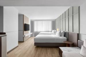 曼谷 曼谷素坤逸20号万怡酒店的酒店客房,设有两张床和一张沙发
